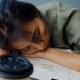 Freelance Asia exhausted lady hard work sleeping with many a paper coffee cup on wooden table at office. Working from living room at home, remotely, social distancing, quarantine for coronavirus.
